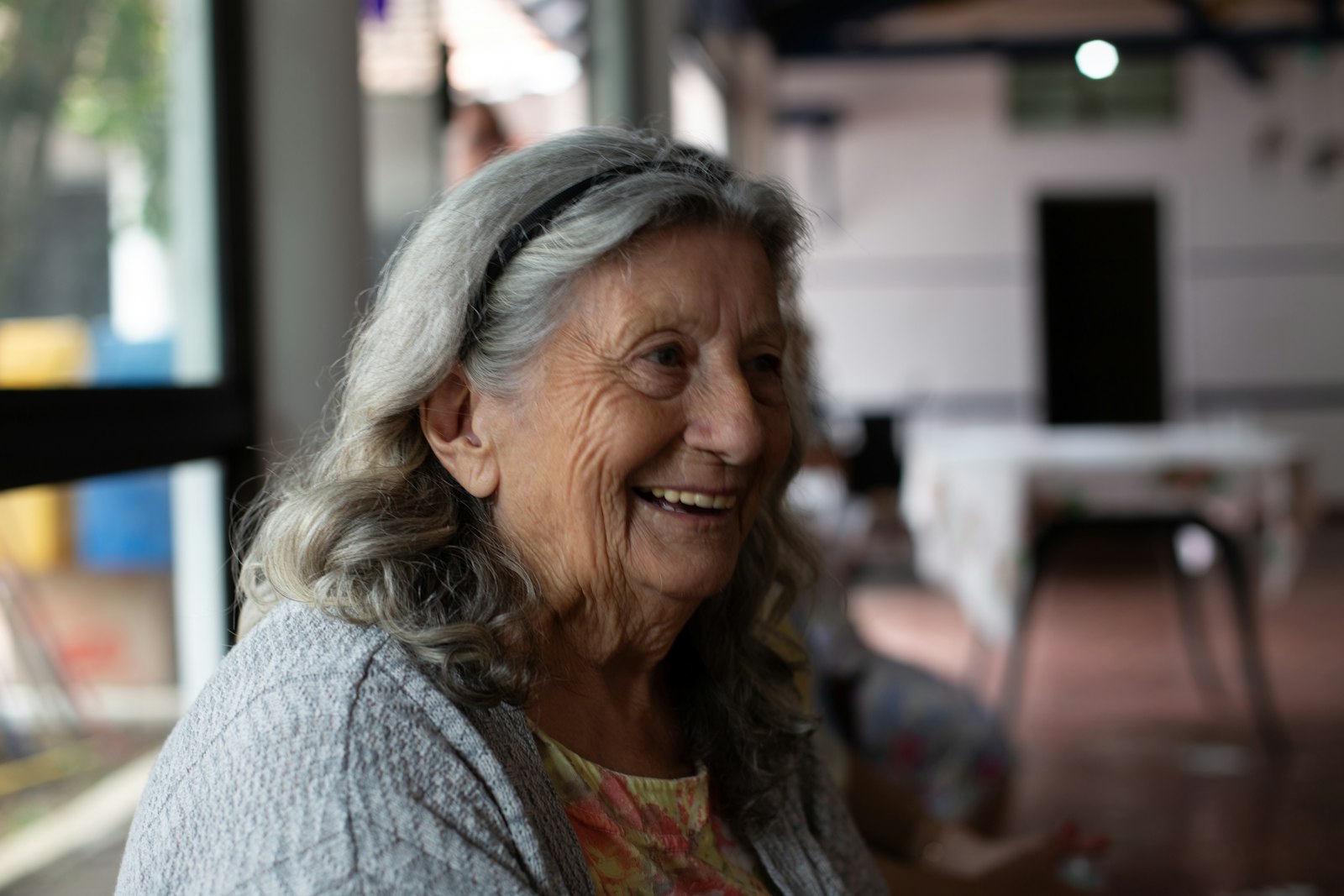 Smiling woman in a gray cardigan after menopause